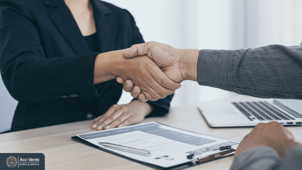 Truck accident victim shaking hands with an attorney after agreeing to legal representation.