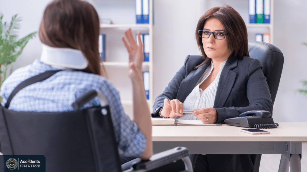 Personal injury attorney consulting with an injured client wearing a neck brace and seated in a wheelchair